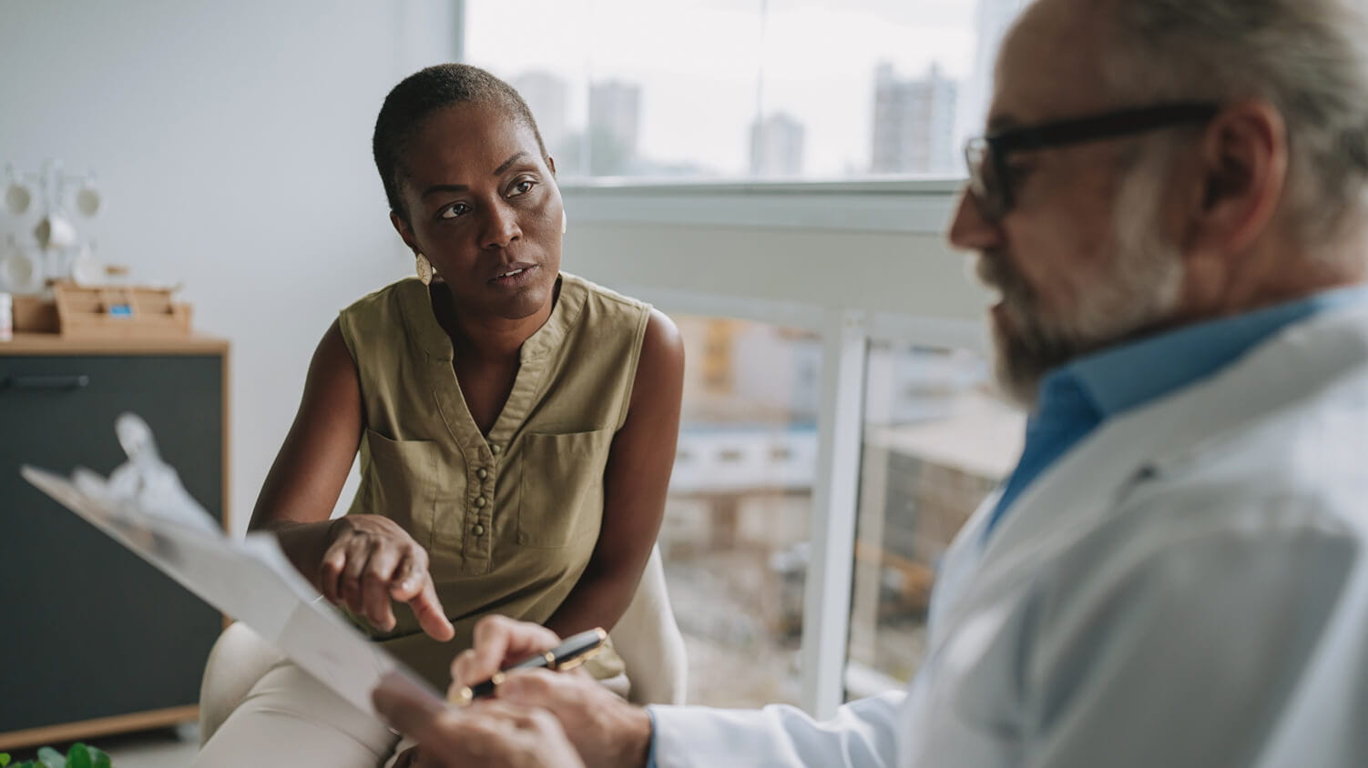 A doctor sitting and reviewing test results with a patient.